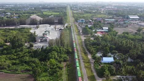 aerial long freight train traveling past old thailand mine