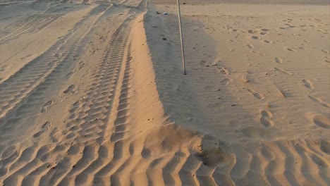 vista en movimiento de un letrero de no nadar en azul amarillo y rojo en una playa de arena desierta con un fondo claro