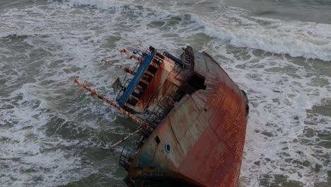 a wrecked rusty old ship washed ashore on a beach filmed in slow motion in lagos, nigeria