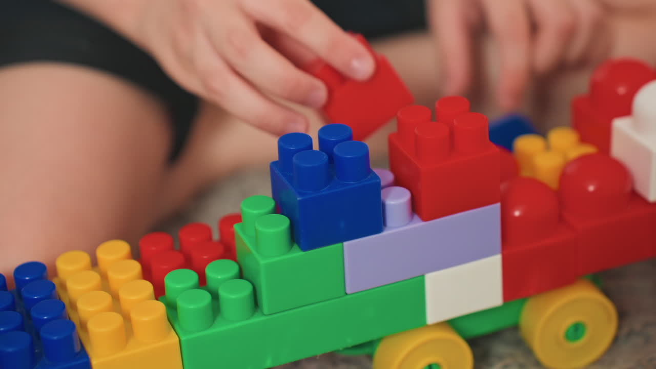 White son focused stacking colorful blocks closeup, handson precision and careful alignment, fine motor practice with bright plastic bricks, calm concentrated play, developmental learning and sensory