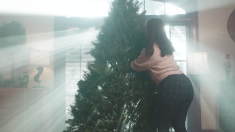 woman preparing a christmas tree indoors