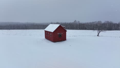 La-Pequeña-Cabaña-Roja-Se-Asienta-Sobre-Un-Telón-De-Fondo-Del-Bosque-Con-Una-Ligera-Capa-De-Nieve