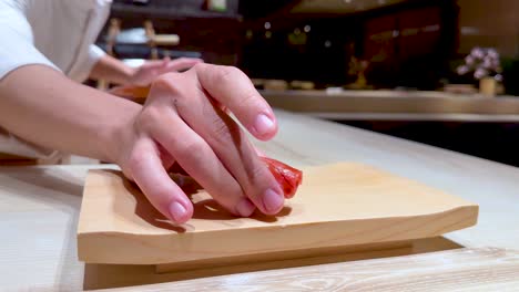 el chef coloca sushi en una tabla de madera.