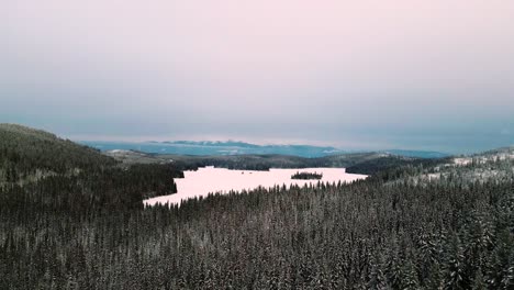 Magia-Invernal-De-La-Hora-Dorada:-Una-Pista-Escénica-Toma-Aérea-Derecha-De-Bosques-Nevados-De-Ensueño-Cerca-Del-Lago-Latremouille-Y-La-Autopista-24-Del-Pequeño-Fuerte-En-Un-Día-Nublado