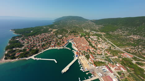 Hochwinkel-Drohne-Mit-Blick-Auf-Die-Insel-Cres-In-Kroatien-Zur-Mittagszeit,-Weitläufige-Dorfhäuser,-Filmischer-Tauchgang-Hinunter-Zum-Hafen