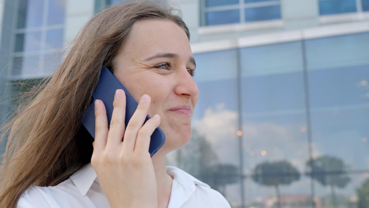 mujer adulta joven sonriente llamando usando un teléfono inteligente, charlando