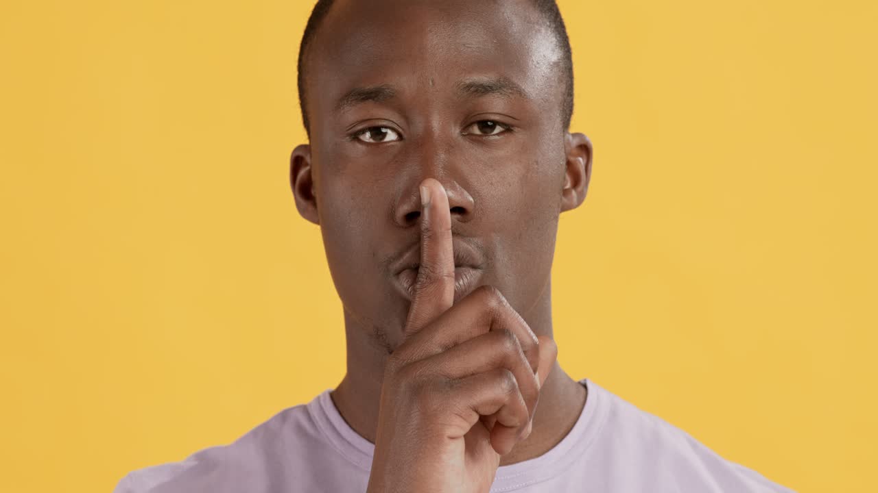 Man with finger on lips