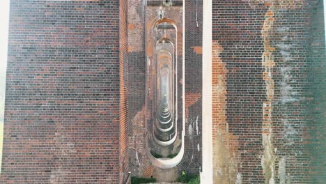 smooth cinematic footage beneath the ouse valley viaduct (balcombe viaduct). iconic arches, historic architecture, perfect for travel, heritage, and architectural projects.