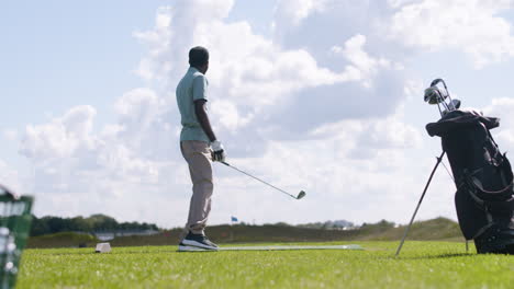 african american man practicing golf on the golf course.