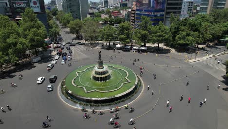 orbital drone shot of fuente de la diana cazadora while cyclists exercise in mexico city