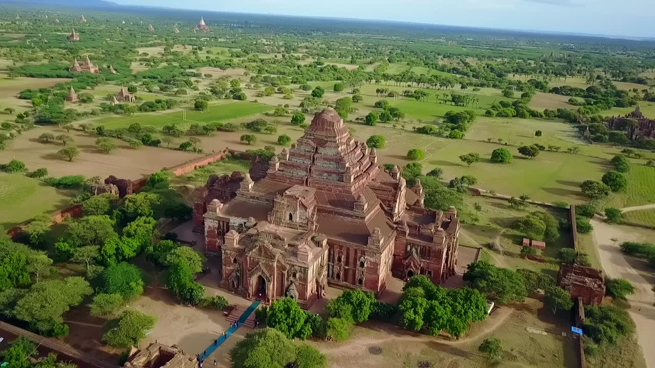 A smooth aerial push-in shot over the Narathu Temple in Bagan, Myanmar, highlighting its architecture and historical significance. Showcasing cultural landmarks and ancient sites.