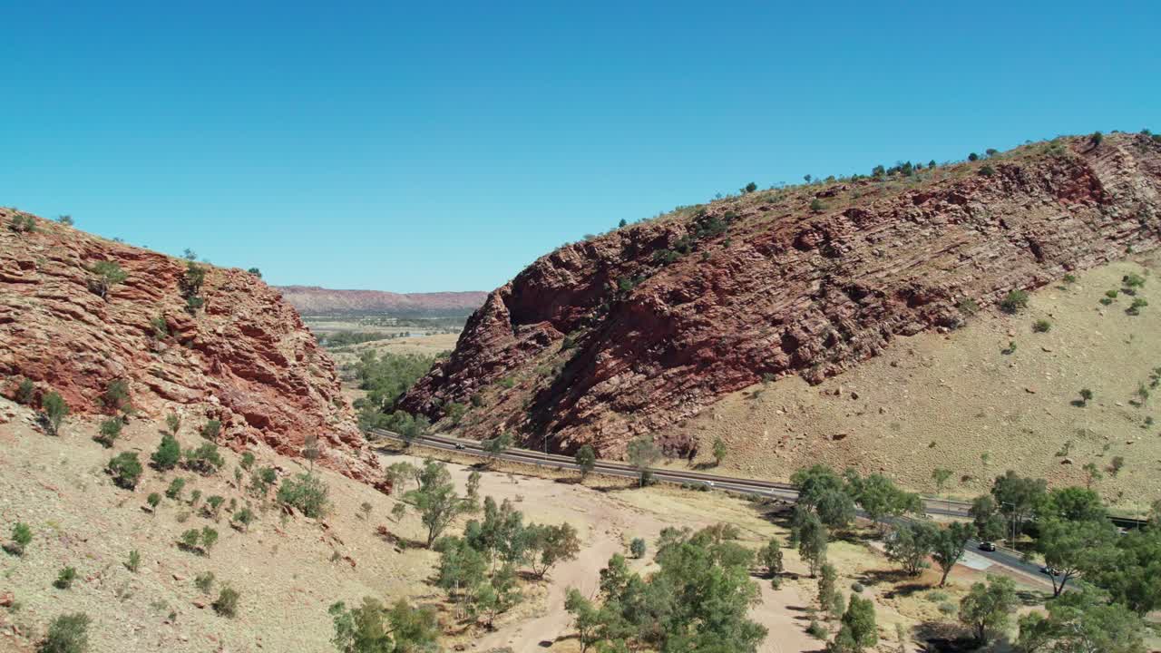 Rising drone footage of Heavitree Gap in the MacDonnell Ranges, Alice Springs, Mparntwe. Northern Territory, Australia. August 2022.