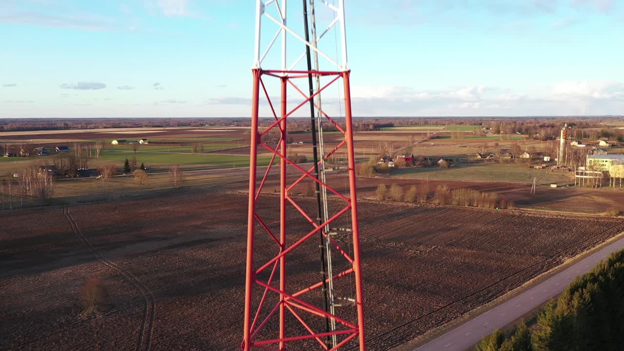 Telecommunication antenna tower in agriculture field in close up drone view