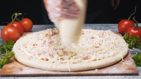 haciendo una pizza con mayonesa y queso