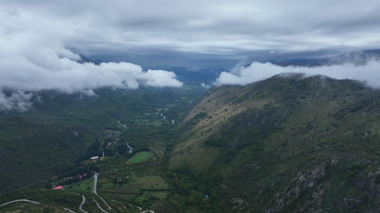 Aerial: mountains and clouds during the day in a rural zone near Cetinje, Montenegro, dolly in drone shot