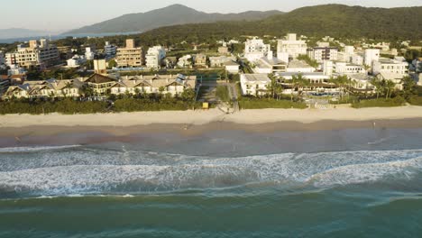 beautiful drone cinematic shot distancing of a brazilian beach with white sand and emerald clear water at sunrise