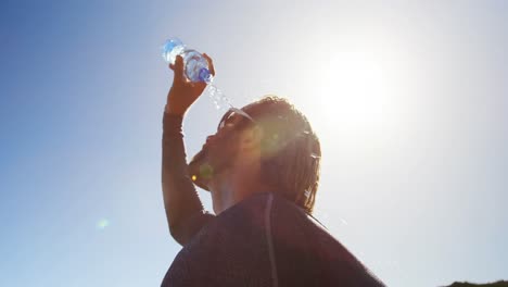 Triathlete-man-pouring-water-on-his-face-on-a-sunny-day