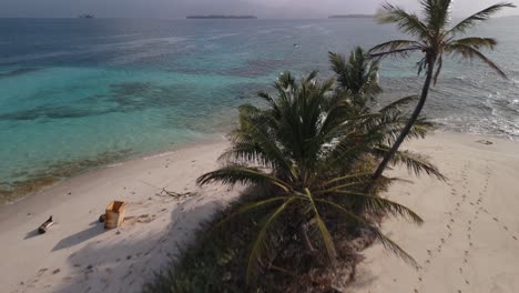 tomada de un avión no tripulado de una isla remota y una pareja remando en el fondo en las islas de san blas, panamá