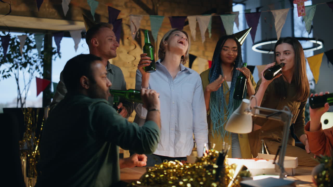 gioiosa squadra che chiacchiera la birra alla festa di compleanno in un ufficio festivo. colleghi felici