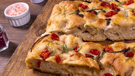 Traditional-Italian-Focaccia-with-pepperoni,-cherry-tomatoes,-black-olives,-rosemary-ando-onion---homemade-flat-bread-focaccia