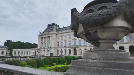 The elegant Royal Palace of Brussels with meticulously maintained gardens and cloudy skies.