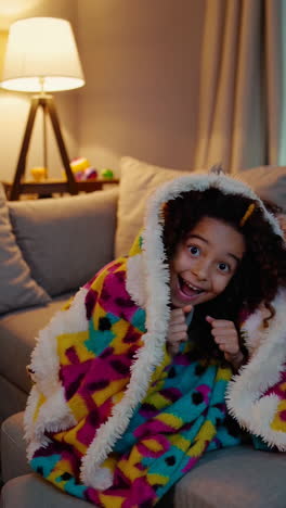 a child expressing a range of emotions while wrapped in a colorful blanket