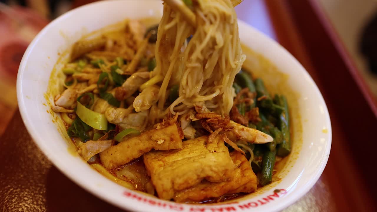 palillos para comer levantando fideos de un tazón de sopa