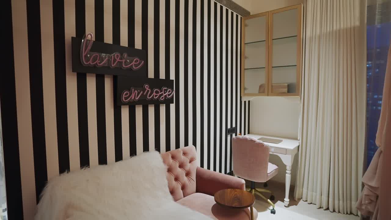 interior de la casa con papel tapiz a rayas verticales en blanco y negro y decoración de pared en rosa lavie