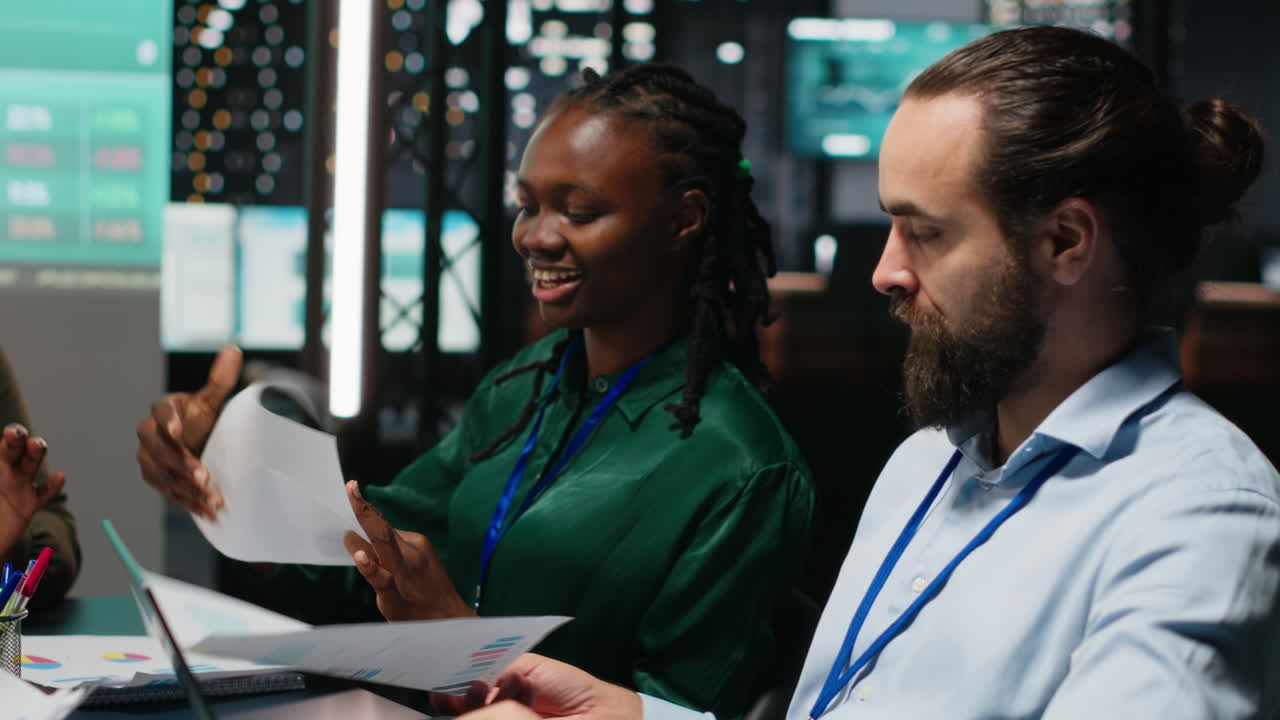 Diverse team of analysts reviewing annual data reports in after hours meeting