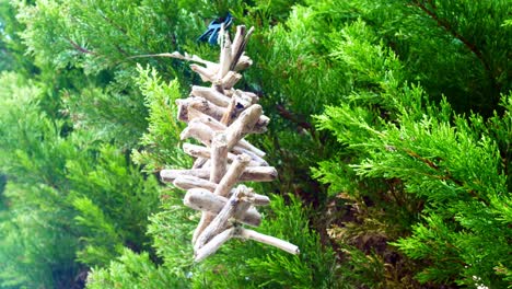 Simple driftwood Viking spiritual Valhalla ladder spinning in breeze hanging in garden