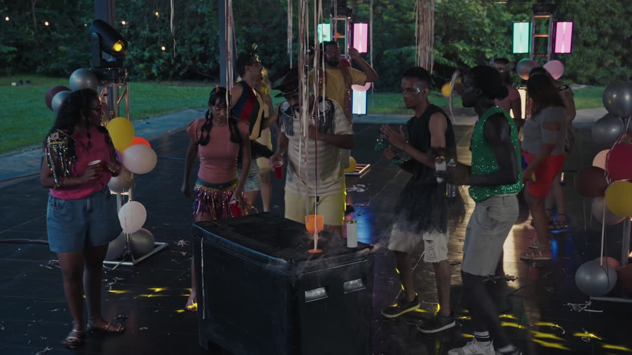 Friends Dancing and Celebrating at a Lively Outdoor Night Party