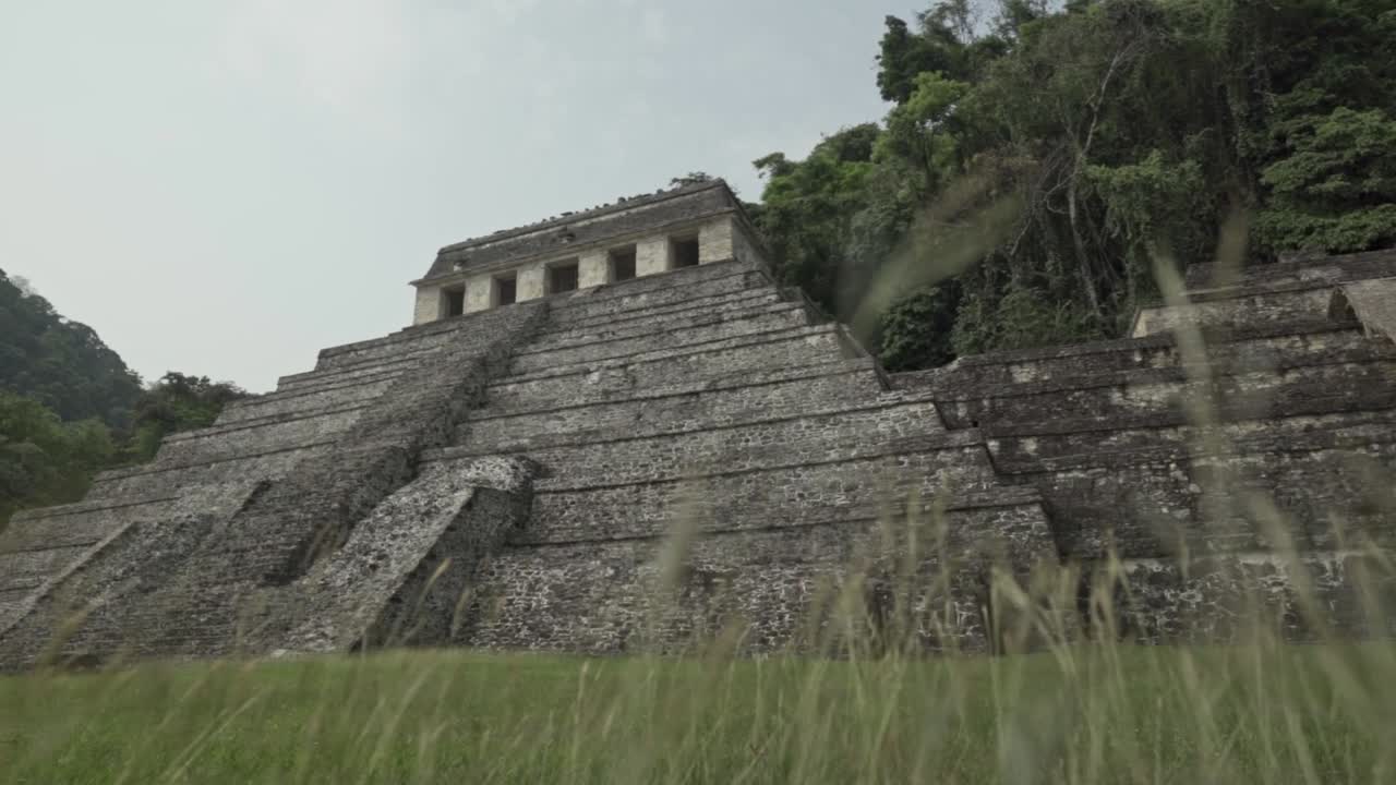 Cinematic clip capturing the weathered grandeur and imposing scale of one of Palenque's primary stepped pyramids, the Temple of the Inscriptions