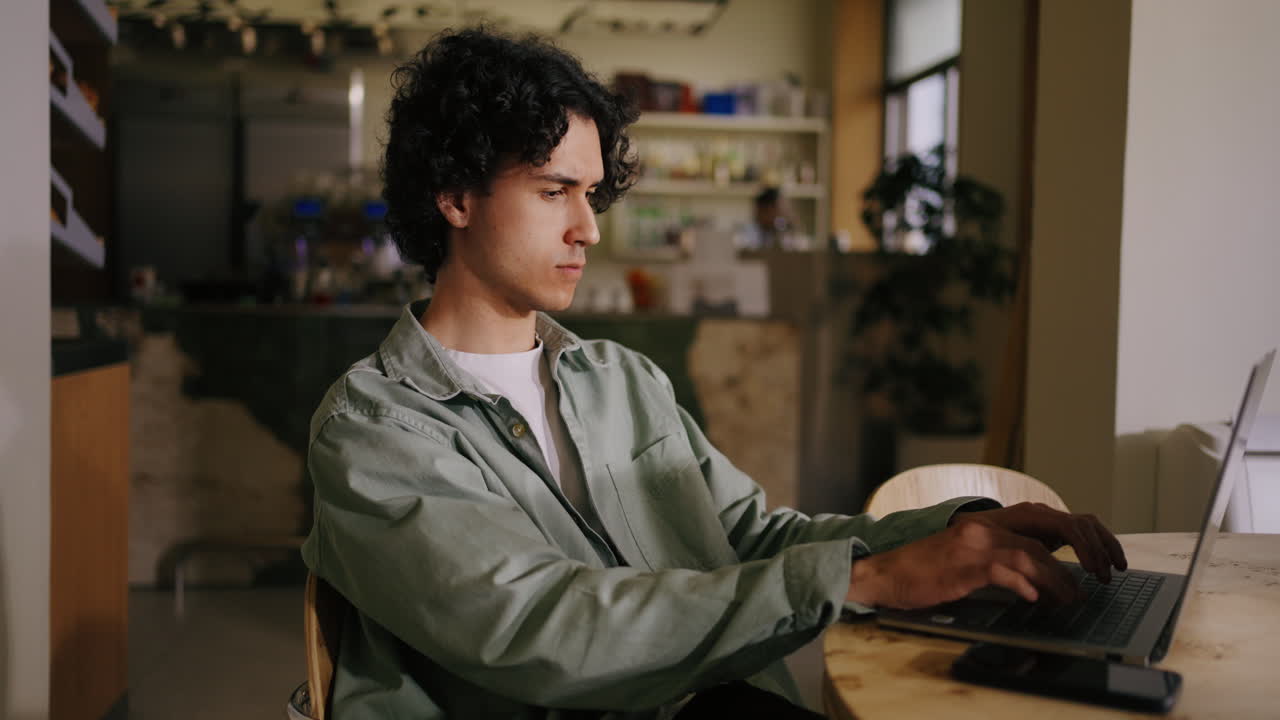 hombre trabajando en su portátil en una cafetería