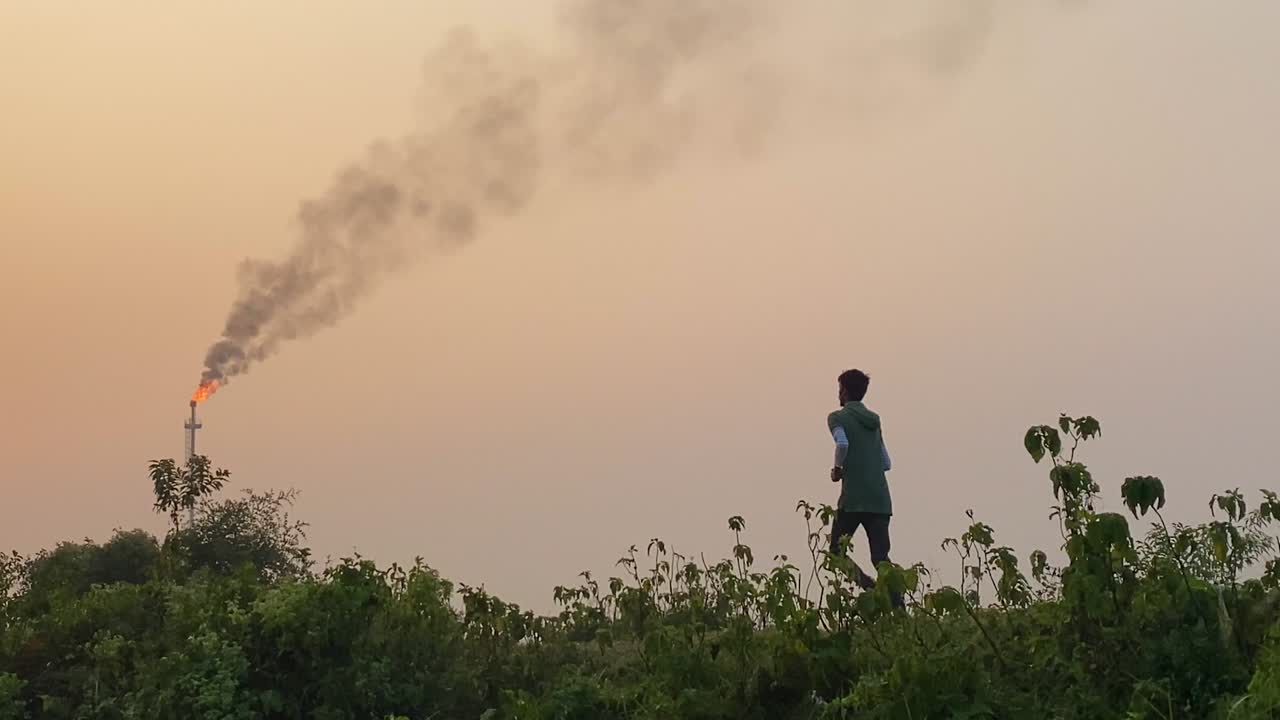 가스 공장 지역, 시골 풍경, 팬을 오염시켜 조깅하는 젊은이의 뒷모습