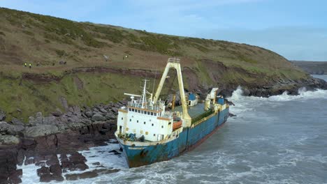 aerial drone shot of waves crashing into an abandoned shipwreck on ireland’s south coast