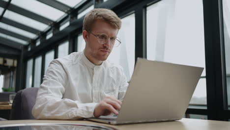 Attentive-millennial-male-manager-employee-busy-at-telework-at-quarantine-time-study-documents-in-corporate-network-from-home-pc