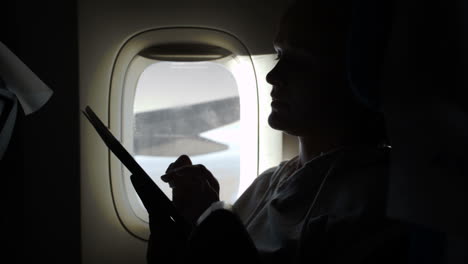 Woman-sitting-by-illuminator-in-plane-with-touch-pad