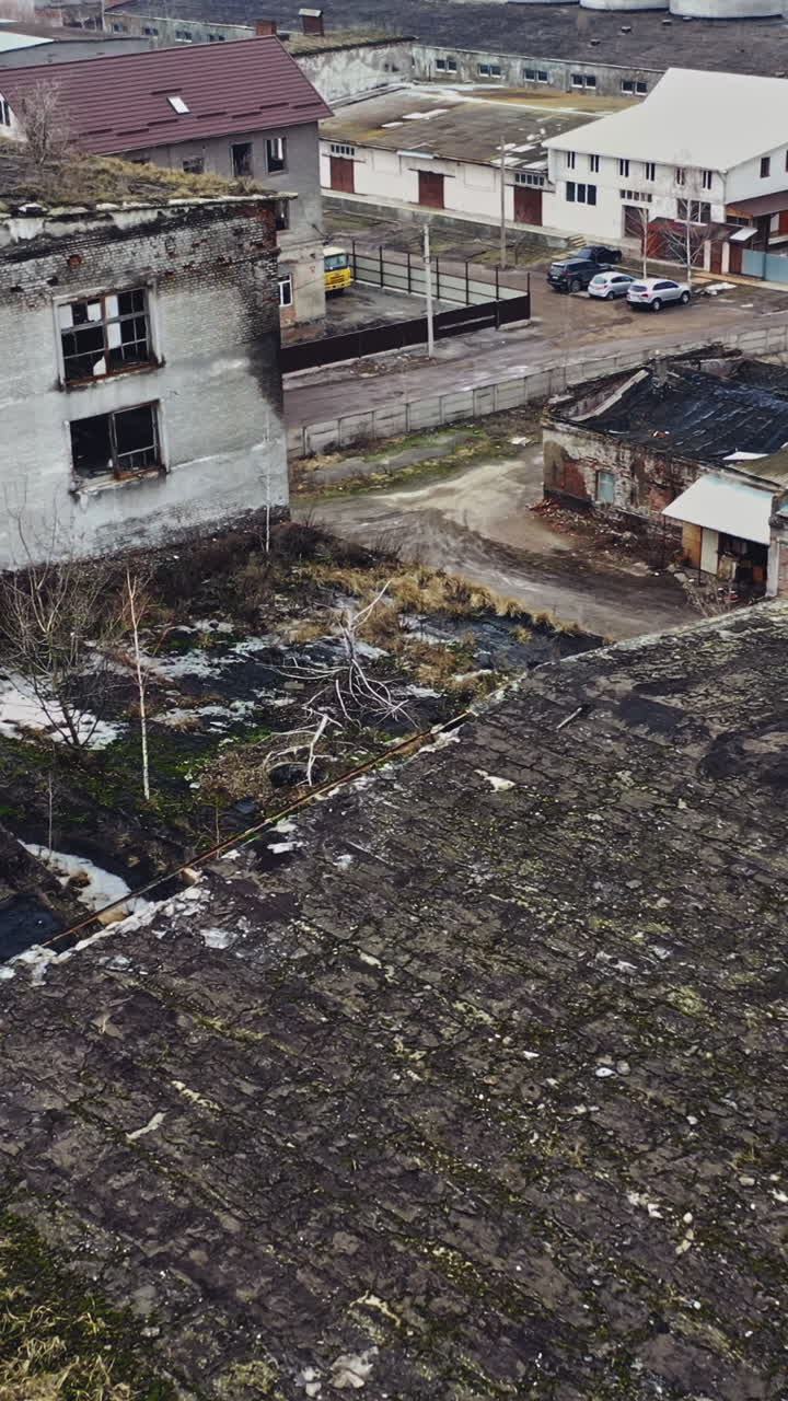Flight over the destroyed factory. Old industrial building for demolition. Aerial view Vertical video