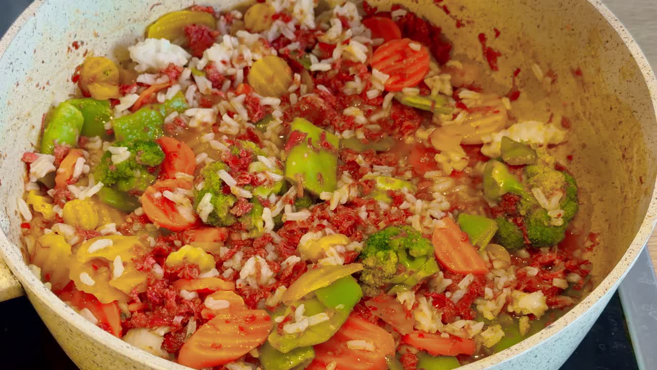 Vibrant homemade rice skillet loaded with minced beef, broccoli, carrots, bell peppers and zucchini in a savory red sauce