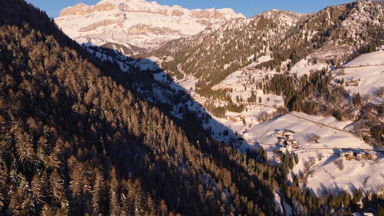 Valli e foreste innevate che conducono verso il Sass Pordoi, viste da Arabba nelle Dolomiti, Italia - Ripresa aerea con drone.