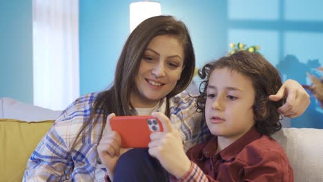 Mutter-Und-Sohn-Sitzen-Zu-Hause-Auf-Dem-Sofa-Und-Nutzen-Das-Smartphone.