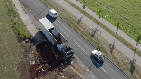 Establecimiento-De-Un-Rodaje-Que-Comienza-Con-Un-Camión-Quemado-Al-Lado-De-La-Carretera,-Revelando-Un-Paisaje-Urbano-Y-Un-Entorno-Circundante-Durante-La-Hora-Pico-De-La-Tarde