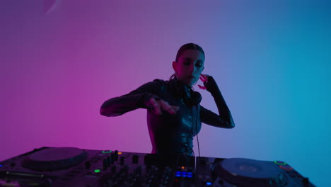 a woman dj in a purple and blue neon lit room