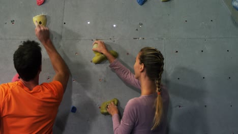 Trainer-Trainiert-Eine-Frau-Zum-Klettern-Einer-Künstlichen-Wand-4k