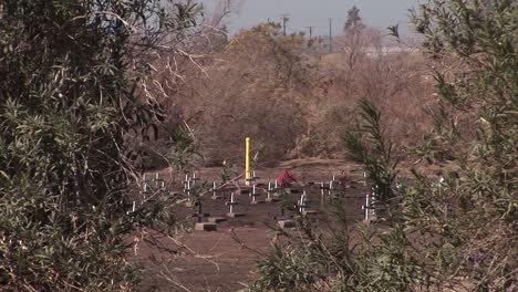 Un-Campo-De-Cruces-De-Madera-Se-Ve-Desde-La-Ladera-De-Una-Colina-Frente-A-Una-Carretera-Transitada