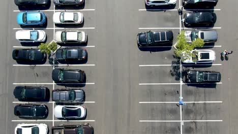 aerial top view of parking lot at shopping mall with varieties of colored vehicles