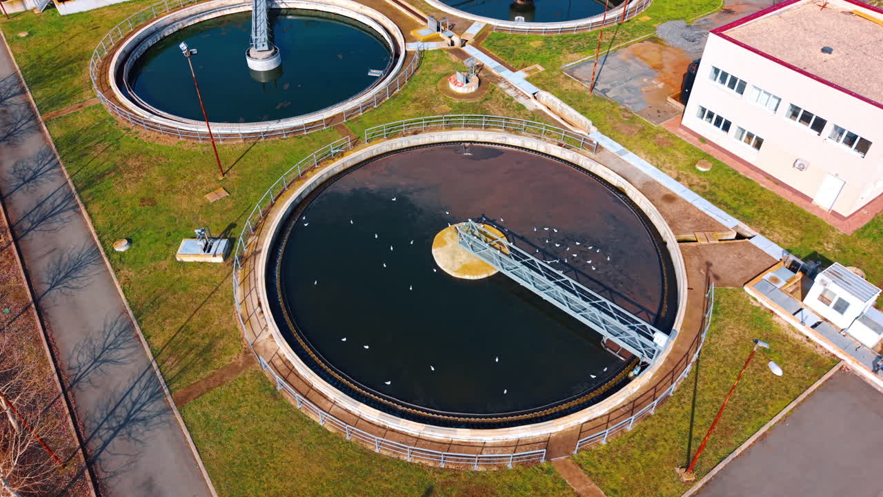 Close up top view of circular primary clarifier tank. Aerial detail of a large circular sedimentation tank with rotating bridge for wastewater treatment process
