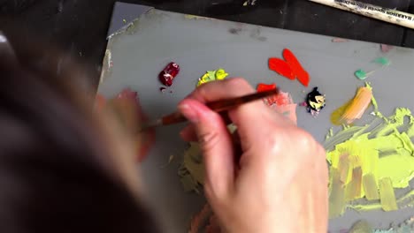 Primer-Plano-De-La-Mano-De-Los-Artistas-Extendiendo-La-Mezcla-De-Pintura-De-Aceite-Con-Pincel