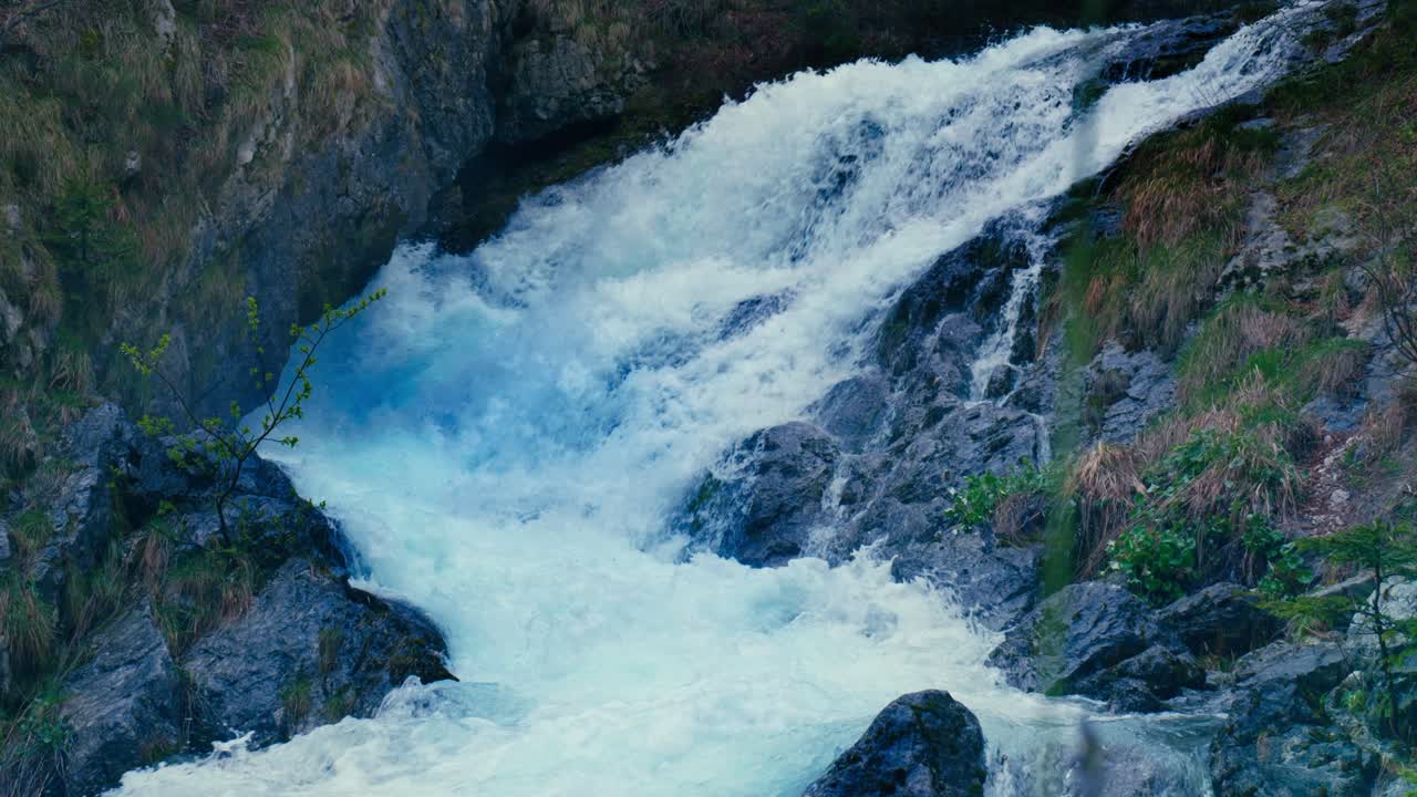 Immerse yourself in the pristine beauty of the Julian Alps with this stunning capture of a mountain river near Kranjska Gora, Slovenia. Crystal-clear turquoise water flows over smooth river rocks.