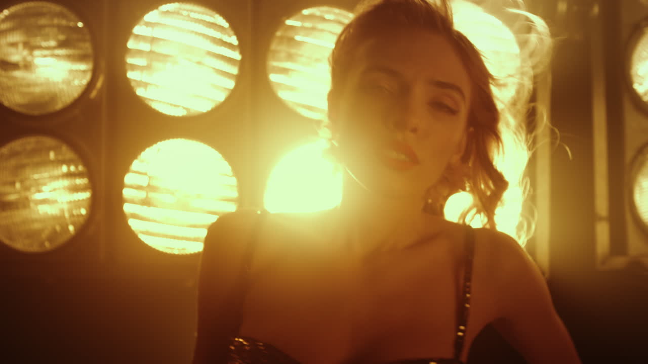 나이트클럽에서 섹시하게 춤추는 섹시한 여자를 유혹하는 근접 촬영. 에로틱하게 움직이는 여인.